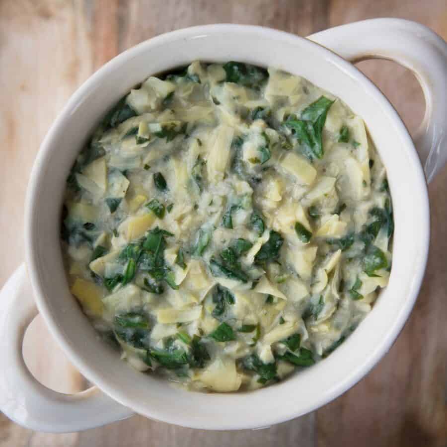 Overhead image of Vegan Spinach Artichoke Dip in a white crock