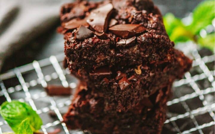 A stack of zucchini brownies on a wire cooling rack