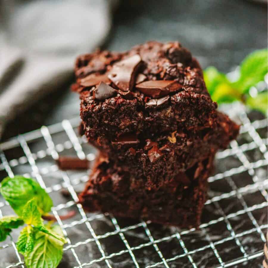 A stack of zucchini brownies on a wire cooling rack