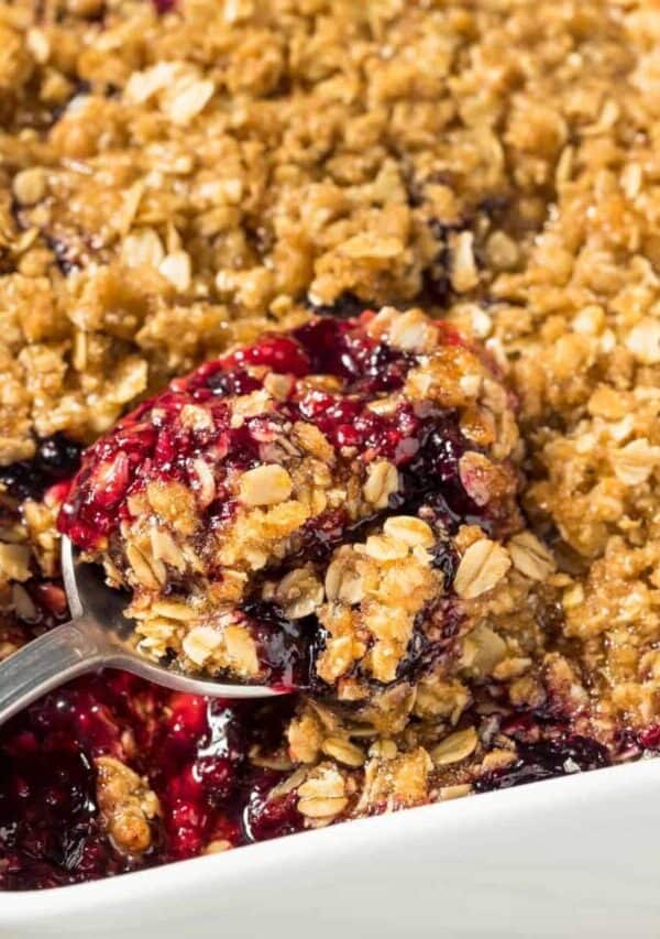 Blackberry Crisp in a white pan with a spoon in it