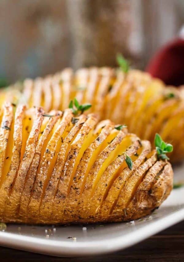 Two Hasselback Potatoes on a white plate
