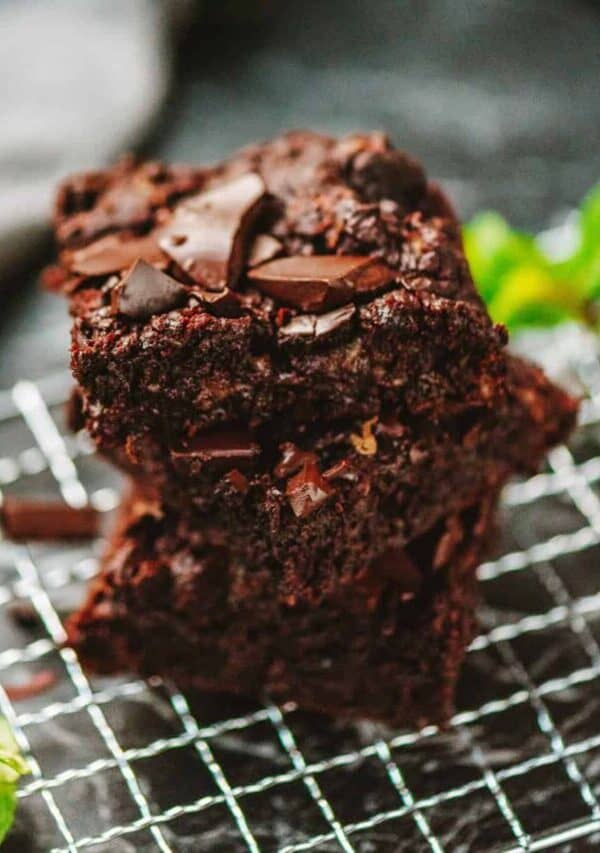 A stack of zucchini brownies on a wire cooling rack