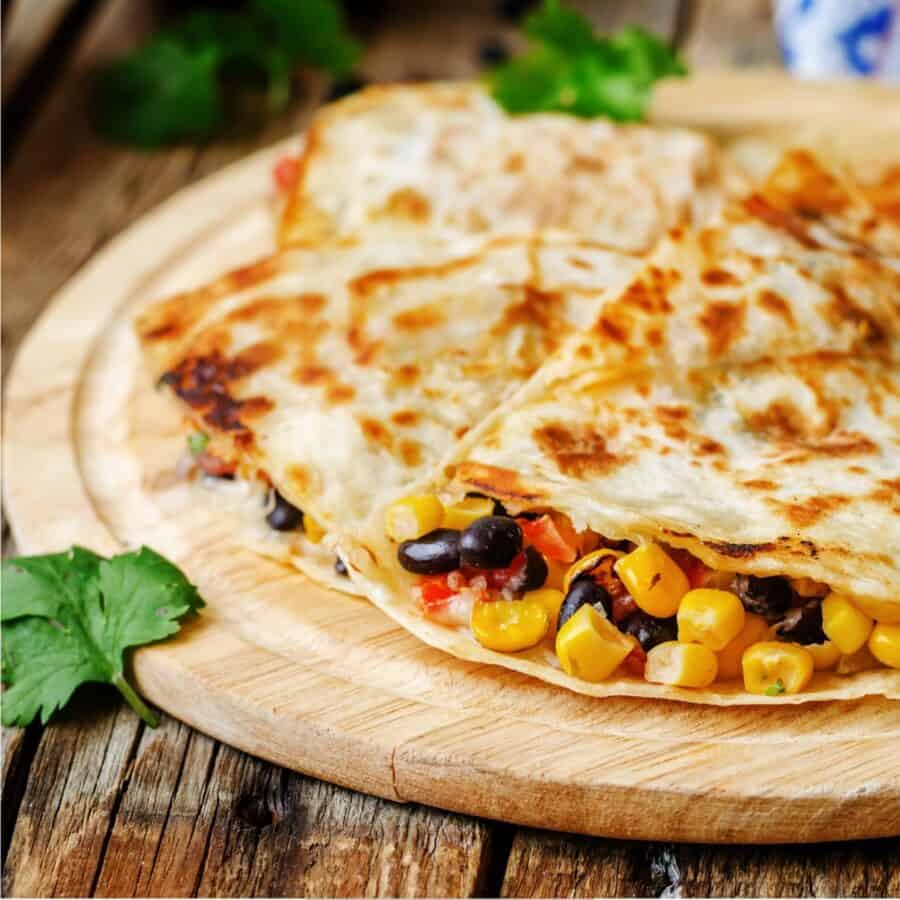 Black Bean Quesadilla cut into pieces on a round cutting board