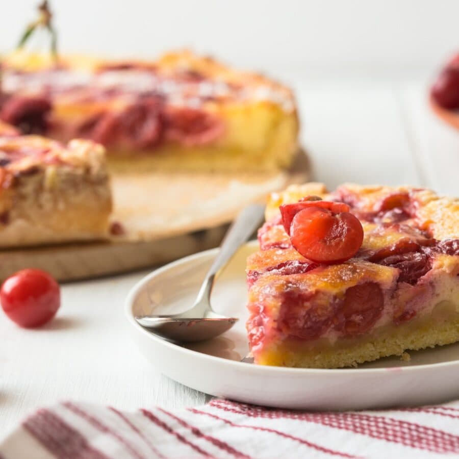 Close up image of a slice of Cherry Clafoutis on a white plate
