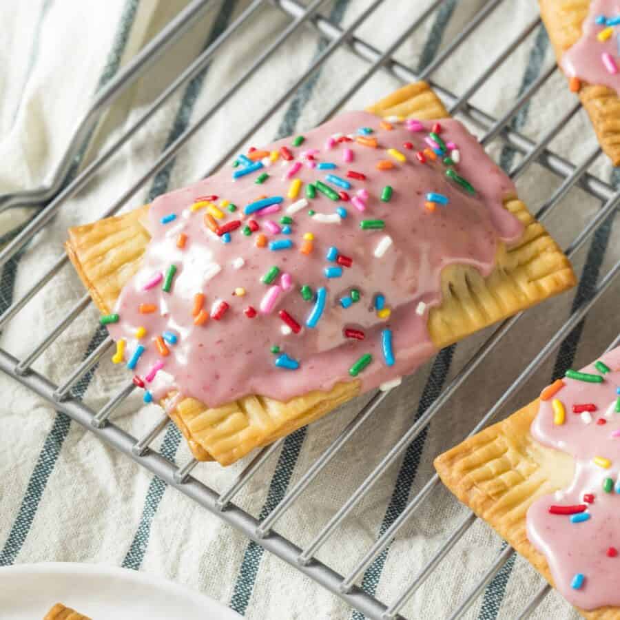 Close up image of Homemade Poptarts with pink frosting and sprinkles on a cooling rack