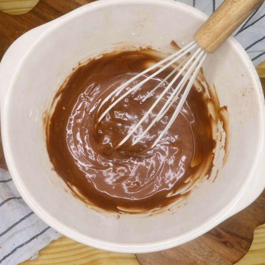 Frosting for Lunch Lady Brownies in a mixing bowl with a whisk