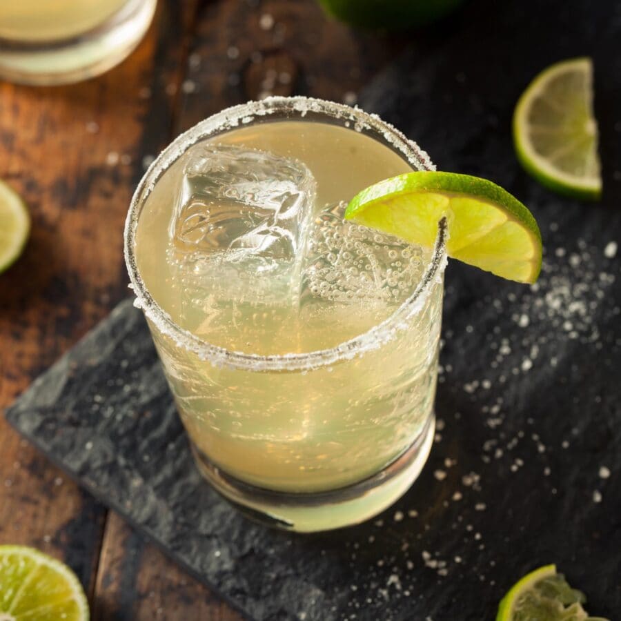 overhead image of a nonalcoholic margarita on a cutting board with lime and salt