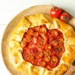 A Tomato Galette on a neutral surface with fresh tomatoes next to it - 8