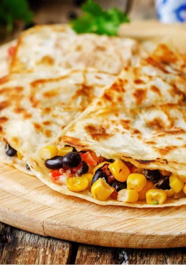 Black Bean Quesadilla cut into pieces on a round cutting board