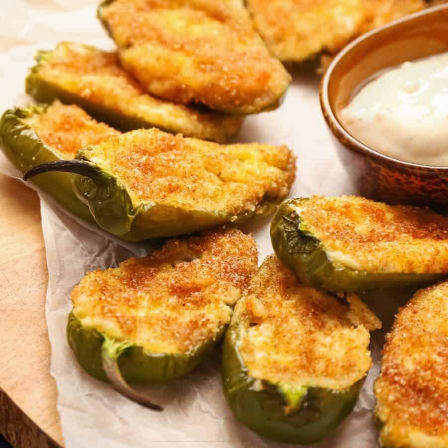 Close up image of Baked Jalapeno Poppers on parchment paper with dipping sauce