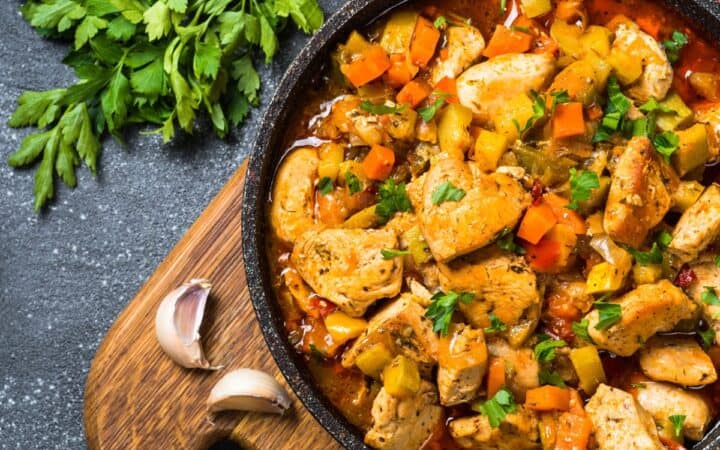 Slow Cooker Chicken Stew in a round dish with fresh herbs and garlic