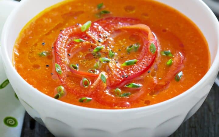 Close up image of Roasted Red Pepper Soup in a white bowl