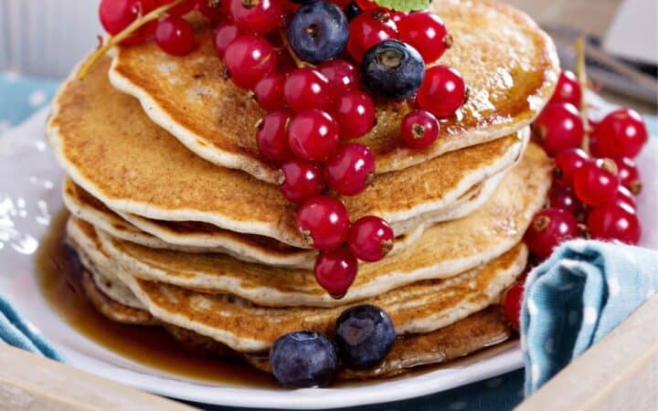Close up image of a stack of Vegan Pancakes with berries on top