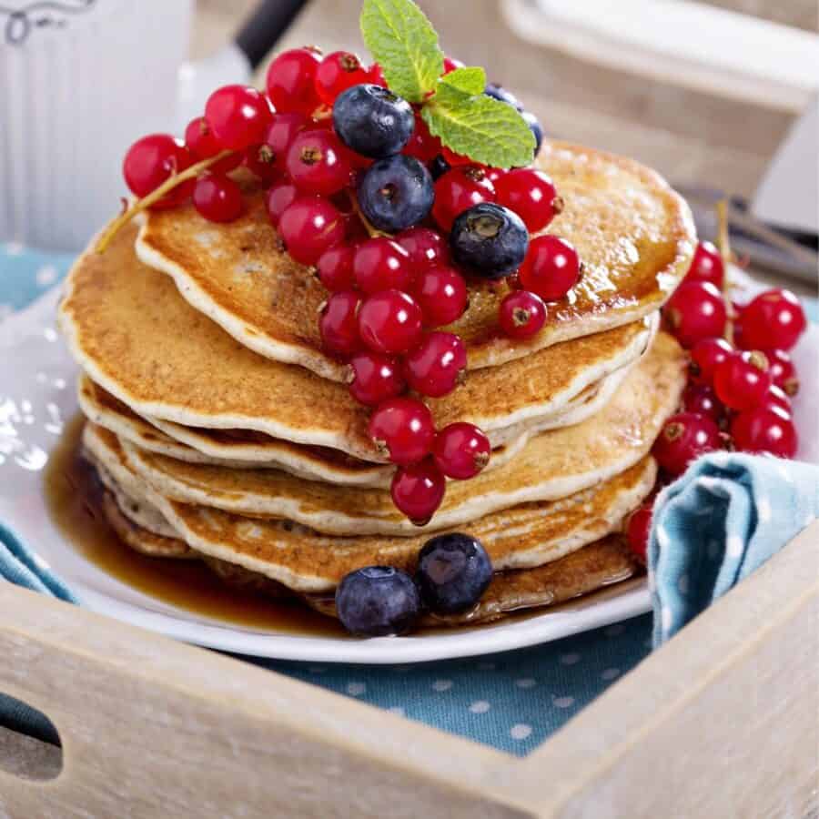 Close up image of a stack of Vegan Pancakes with berries on top