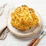 Overhead image of Whole Roasted Caulfilower on a white plate - 7