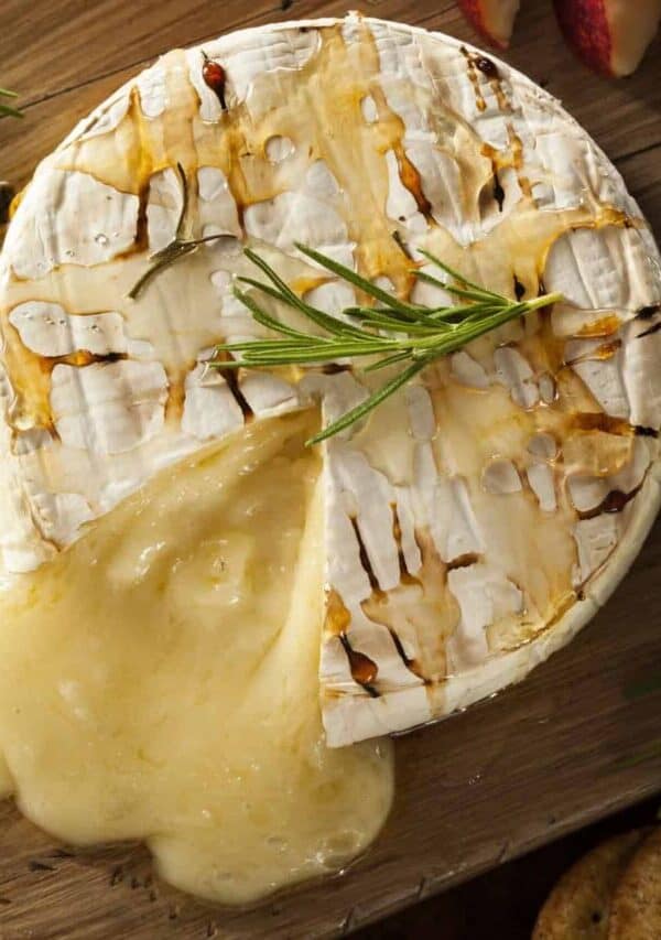 Overhead image of Baked Brie with a slice cut out of it on a cutting board