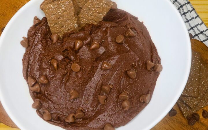 Overhead image of brownie batter dip in a white bowl with chocolate graham crakcer dippers