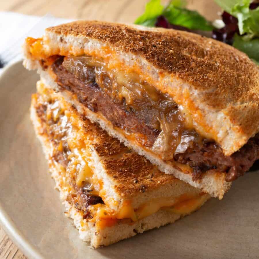 A Patty Melt Sandwich on a plate with salad on the side
