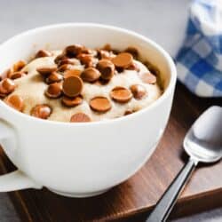 Close up image of chocolate chip mug cake in a white coffee mug