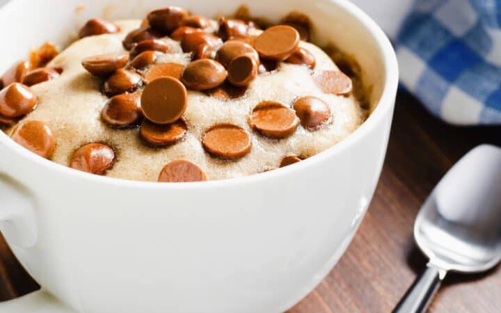 Close up image of chocolate chip mug cake in a white coffee mug