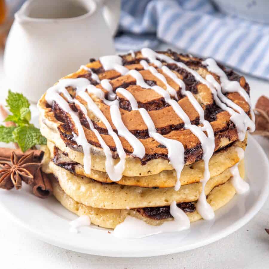 A Stack of Cinnamon Roll Pancakes on a white plate
