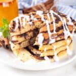 Close up image of Cinnamon Roll pancakes with a slice cut out of them - 8