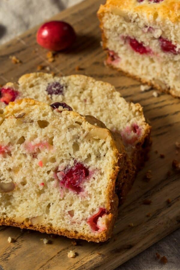 Cranberry Cake on a wooden cutting board with slices