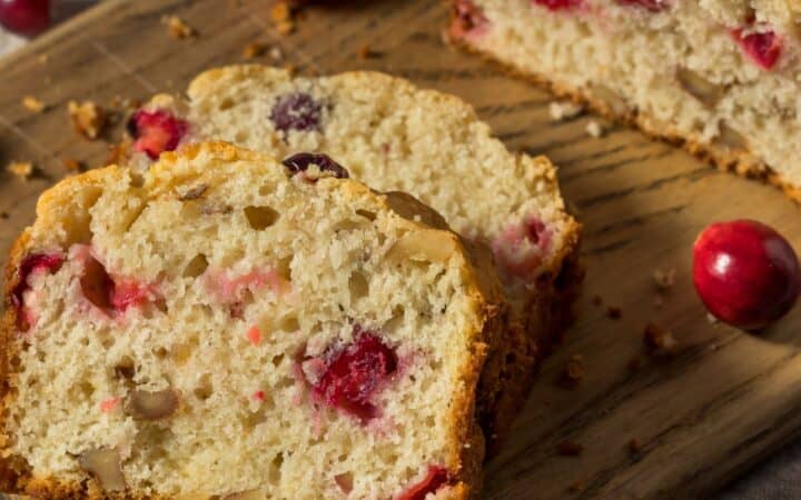 Cranberry Cake on a wooden cutting board with slices