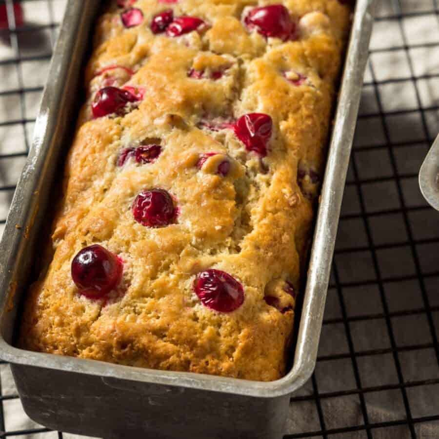 Cranberry Cake in a loaf pan on a cooling rack