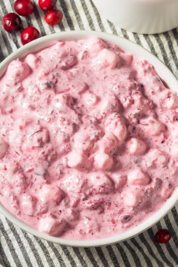 Overhead image of Cranberry Fluff in a white bowl with cranberries scattered around it