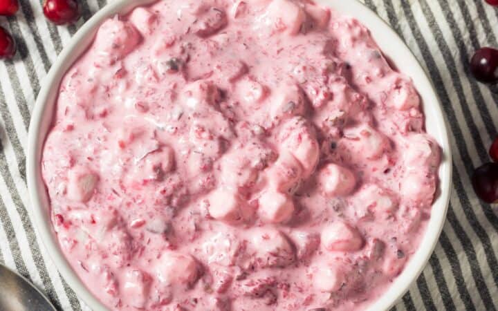 Overhead image of Cranberry Fluff in a white bowl with cranberries scattered around it