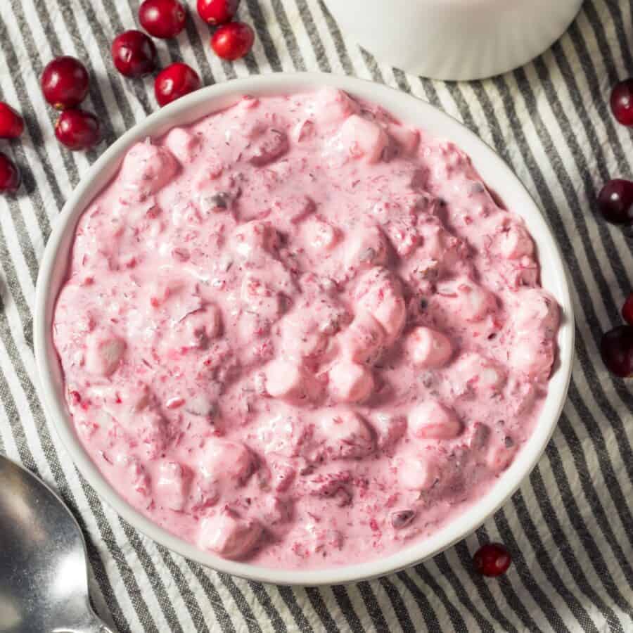 Overhead image of Cranberry Fluff in a white bowl with cranberries scattered around it