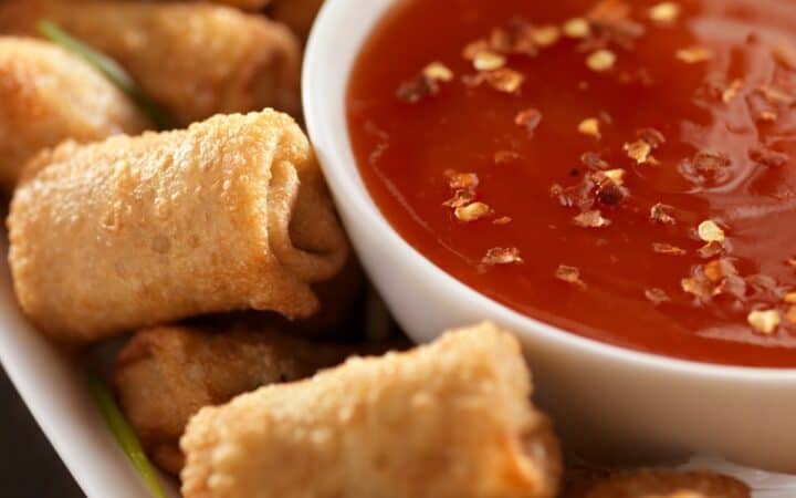 Egg Roll Dipping sauce in a white bowl next to mini egg rolls