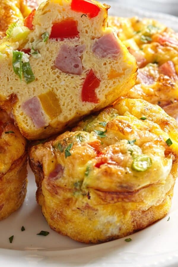 Frittata Muffins on a white plate with one cut in half