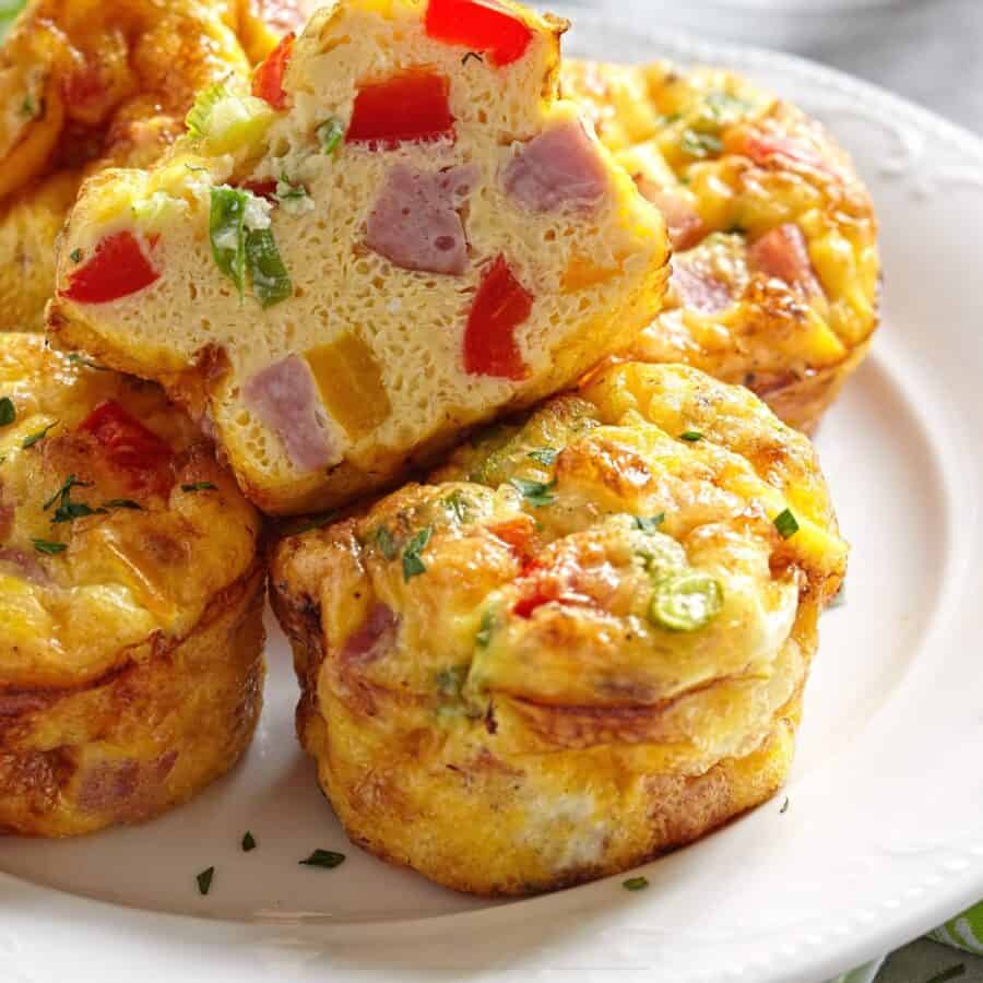 Frittata Muffins on a white plate with one cut in half