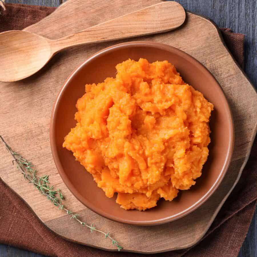 Overhead image of mashed sweet potatoes in a wooden bowl