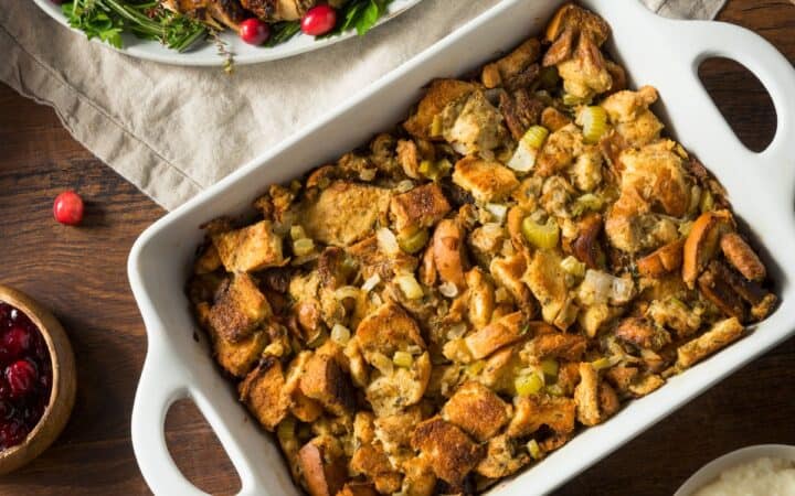 Overhead image of Sausage Stuffing in a baking dish next to sliced turkey