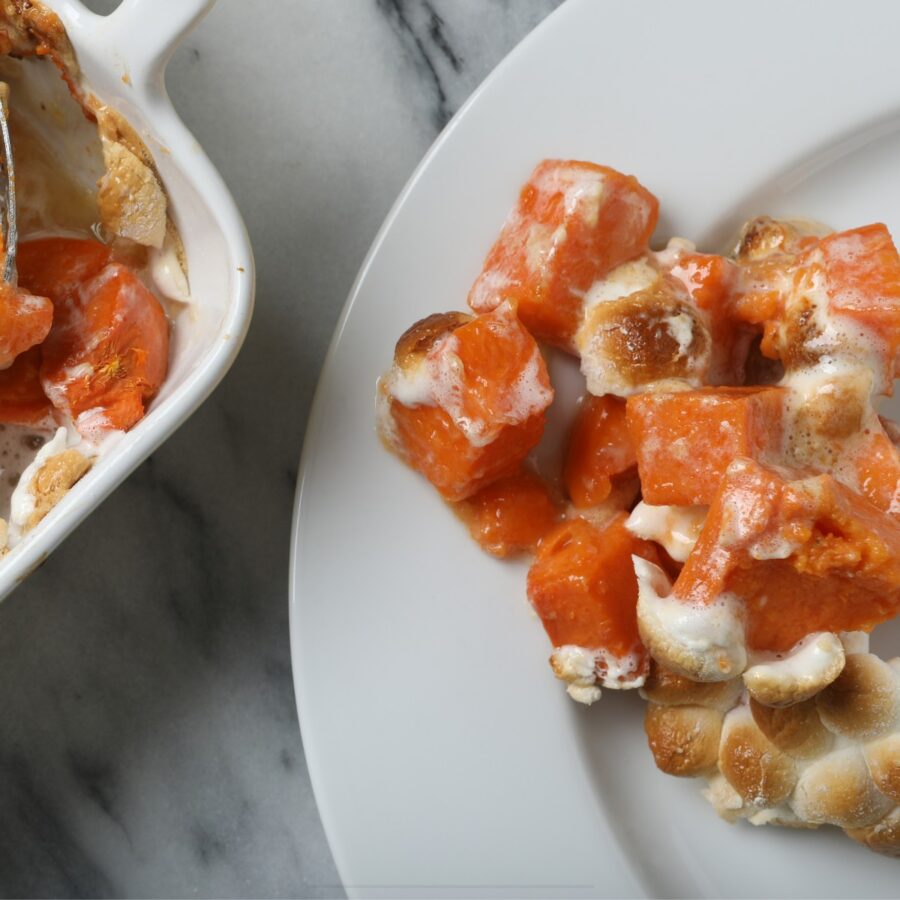 Close up image of a serving of sweet potato casserole on a white plate
