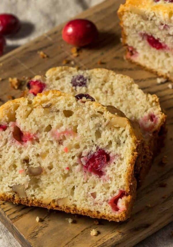 Cranberry Cake on a wooden cutting board with slices