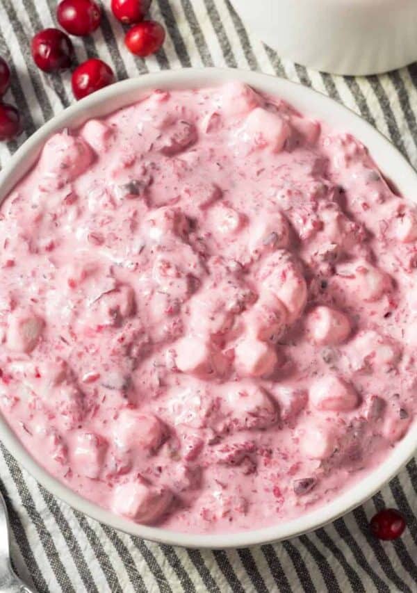 Overhead image of Cranberry Fluff in a white bowl with cranberries scattered around it