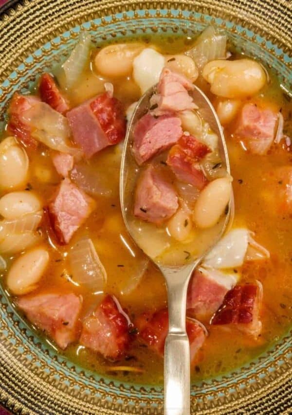 Overhead image of slow cooker ham and beans in a bowl with a spoon