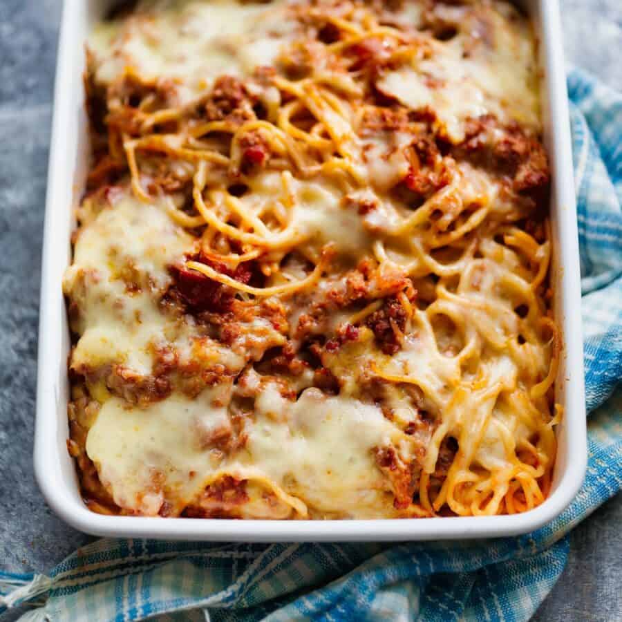 Overhead image of baked spaghetti on a blue cloth