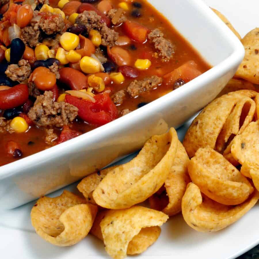 Crockpot Taco Soup with corn chips on a plate next to the bowl