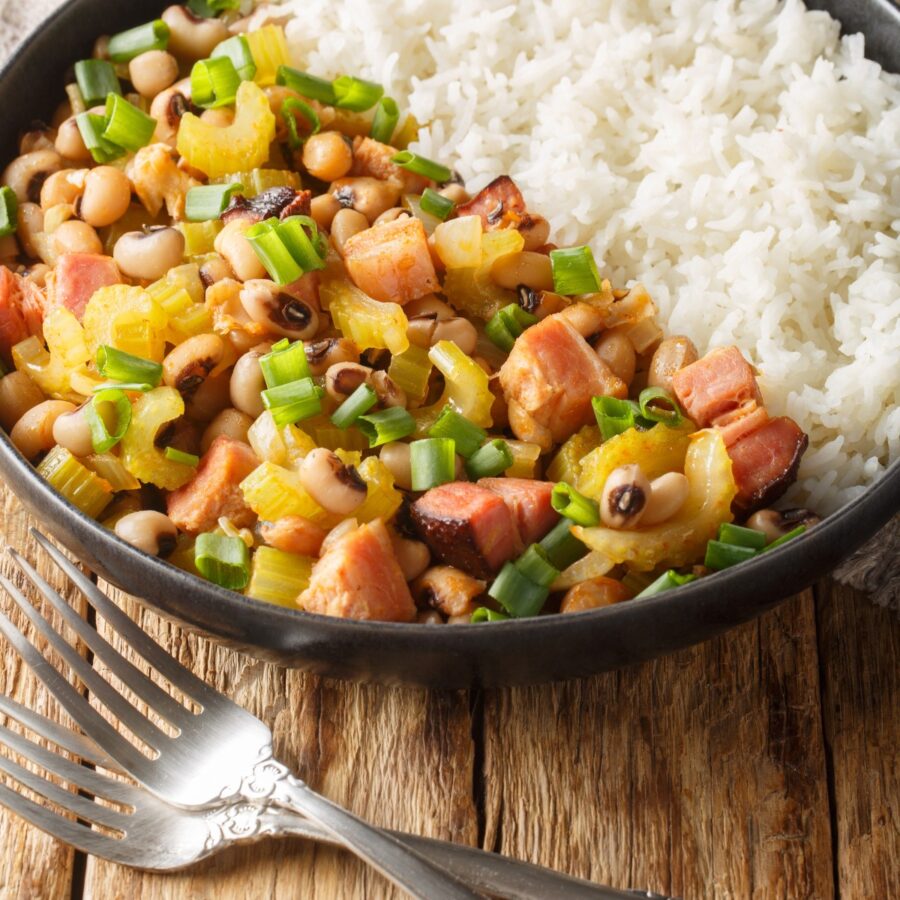 Close up image of Hoppin John on a deep plate on a wooden surface
