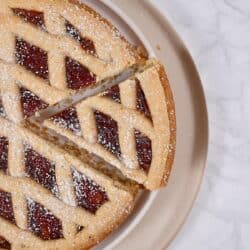 Overhead image of a piece being taken out of a linzer tart