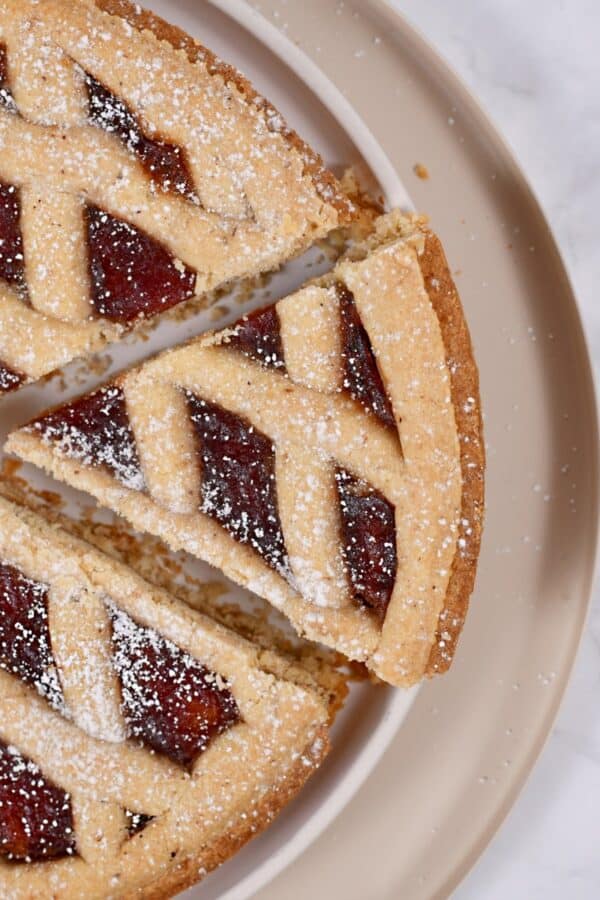 Overhead image of a piece being taken out of a linzer tart