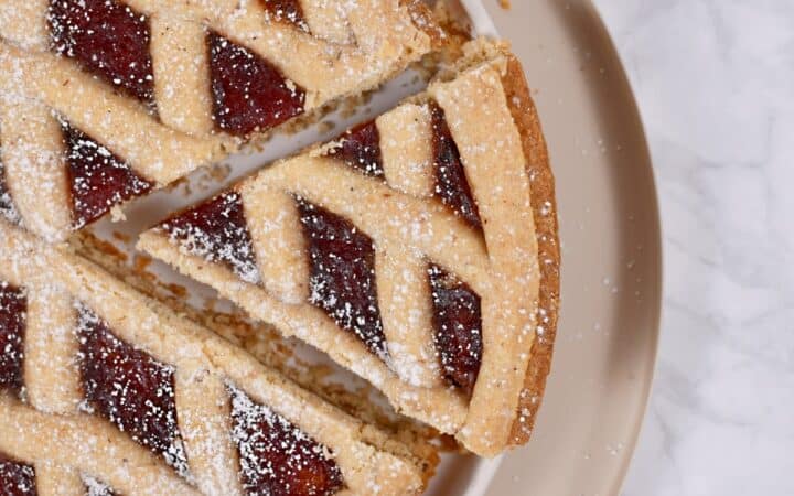 Overhead image of a piece being taken out of a linzer tart