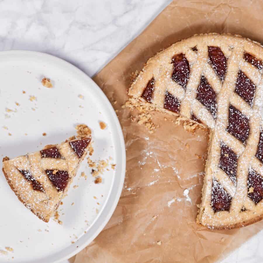 Placing a slice of a linzer tart on a white plate