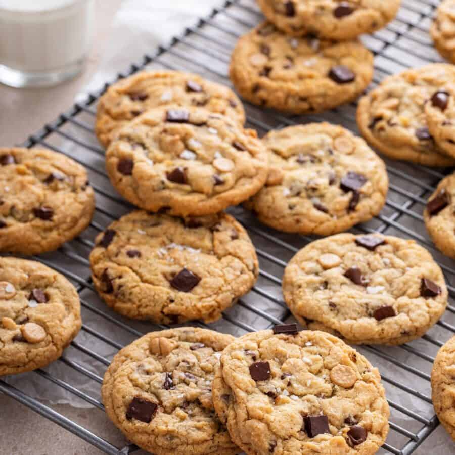 A dozen salted caramel chocolate chip cookies on a cooling rack
