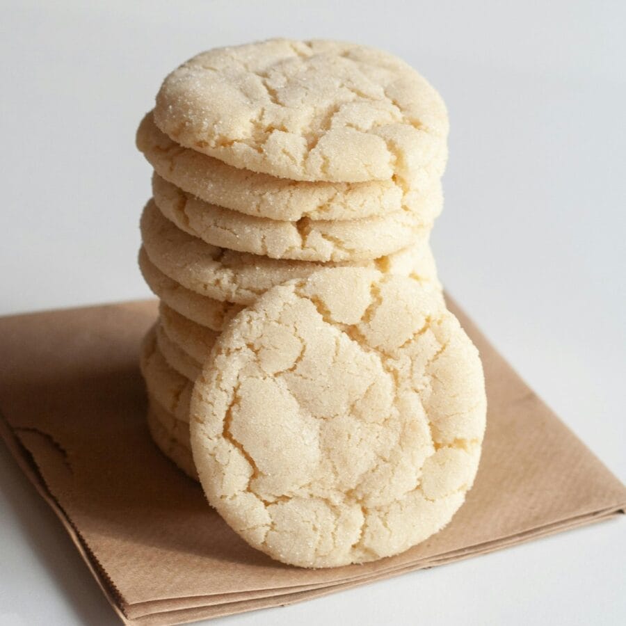 Soft sugar cookies stacked on top of eachother with one leaning against the stack